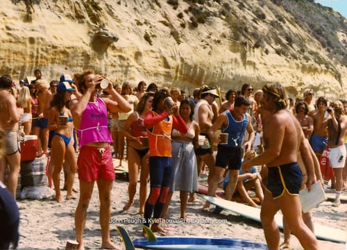 A cup in one hand, boards behind