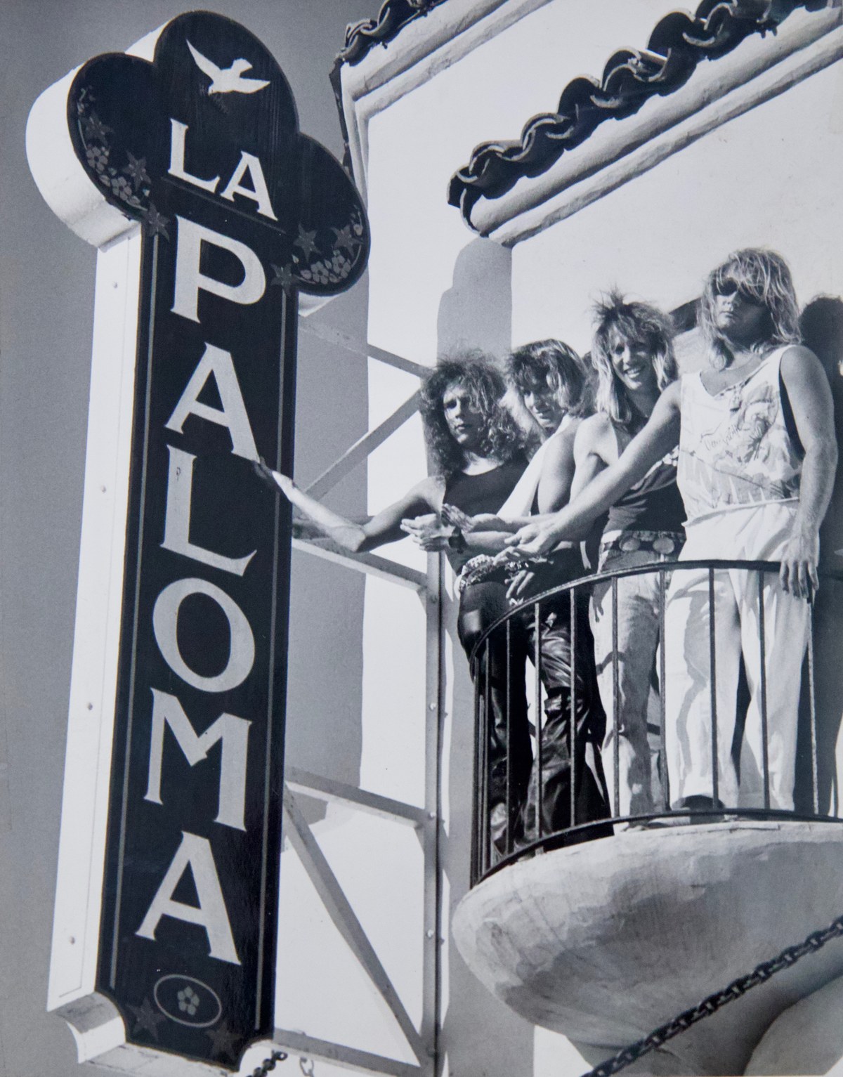 Snakebyte posed on the balcony of the La Paloma Theater beside its vertical marquee, 1985