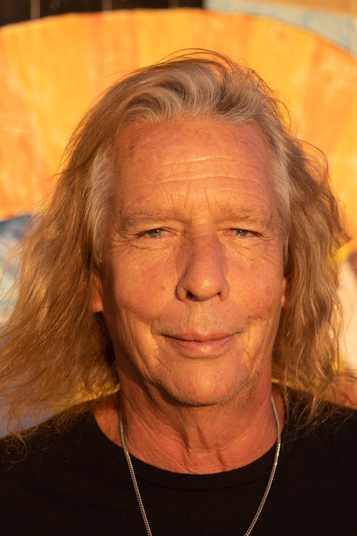 Vertical portrait of Wally Passet against the painted backdrop, 2021