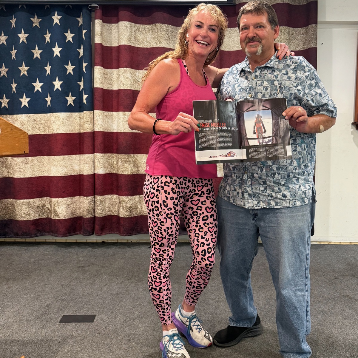 Denise Mueller and Kyle Thomas holding the open Encinitas Magazine spread at the Encinitas Elks Lodge