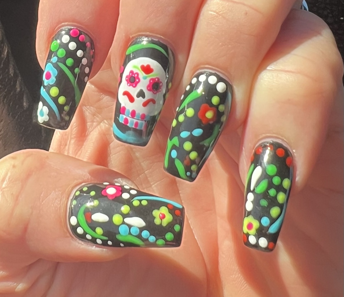 Close-up of Denise Mueller’s hand-painted Day of the Dead sugar skull nails