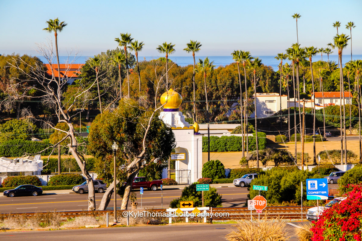 The golden lotus domes of the Self-Realization Fellowship above Coast Highway 101, the Vulcan Avenue sign and the Coaster tracks, Encinitas California